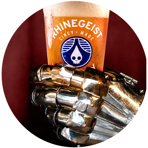 an hand in armor holds a glass of beer with the Rhinegeist logo on it